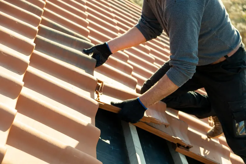 Roofer replacing tiles during a roof repair in Harrogate